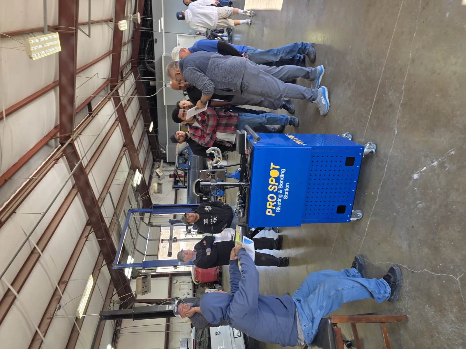 Technicians gathered around a Pro Spot riveting and bonding station during hands-on instruction