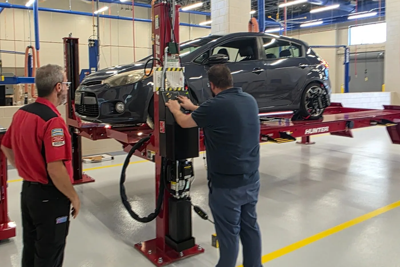 TAG technicians running a Hunter alignment session with a vehicle on the rack